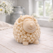 Load image into Gallery viewer, A highly detailed handmade vegan soap sculpted in the shape of a sturdy ram with a thick coat of tight, curly wool and large, elegant curved horns, displayed on a light wooden surface in a bright farmhouse setting.