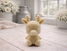 Load image into Gallery viewer, A 3D handmade vegan soap crafted into a cute, sitting baby reindeer with small antlers, rounded features, and a sweet expression, set against a bright farmhouse window.