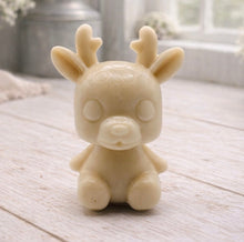 Load image into Gallery viewer, A 3D handmade vegan soap crafted into a cute, sitting baby reindeer with small antlers, rounded features, and a sweet expression, set against a bright farmhouse window.