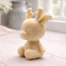 Load image into Gallery viewer, A 3D handmade vegan soap crafted into a cute, sitting baby reindeer with small antlers, rounded features, and a sweet expression, set against a bright farmhouse window.