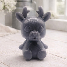 Load image into Gallery viewer, A 3D handmade vegan soap crafted into a cute, sitting baby reindeer with small antlers, rounded features, and a sweet expression, set against a bright farmhouse window.