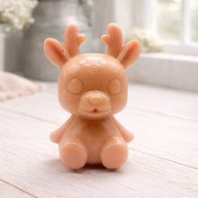 Load image into Gallery viewer, A 3D handmade vegan soap crafted into a cute, sitting baby reindeer with small antlers, rounded features, and a sweet expression, set against a bright farmhouse window.