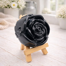 Load image into Gallery viewer, A handmade vegan soap, intricately sculpted in the shape of a large, blooming rose flower with layered petals, displayed on a small wooden easel against a bright win
