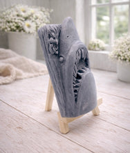 Load image into Gallery viewer, A 3D handmade vegan soap sculpted into a realistic great white shark head with its jaws wide open to reveal multiple rows of sharp teeth, displayed on a miniature wooden easel in a bright farmhouse setting.
