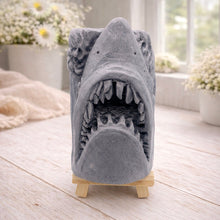 Load image into Gallery viewer, A 3D handmade vegan soap sculpted into a realistic great white shark head with its jaws wide open to reveal multiple rows of sharp teeth, displayed on a miniature wooden easel in a bright farmhouse setting.