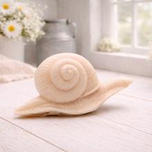 Load image into Gallery viewer, A highly detailed handmade vegan soap gift, sculpted in the shape of a realistic snail with a prominent spiralled shell and a textured, leathery body, displayed on a light wooden surface. Handmade in Blackpool.