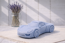 Load image into Gallery viewer, Blue sports car-shaped vegan soap gift on a light surface with a vase of lavender in the background