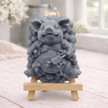 Load image into Gallery viewer, A detailed handmade vegan soap, sculpted as a cheerful pig sitting in a mound of bubbles and holding a scrubbing brush, displayed on a miniature wooden easel against a soft farmhouse window background