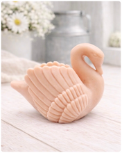 Load image into Gallery viewer, handmade vegan soap, sculpted into the shape of a graceful swan with detailed feathering on its wings and a curved neck, displayed on a light wooden surface in a bright farmhouse setting.