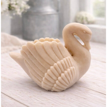 Load image into Gallery viewer, handmade vegan soap, sculpted into the shape of a graceful swan with detailed feathering on its wings and a curved neck, displayed on a light wooden surface in a bright farmhouse setting.