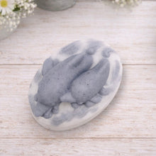 Load image into Gallery viewer, A handmade vegan soap featuring two grey dolphins jumping through white frothy waves; the base is white, and the dolphins are highly detailed, displayed on a light wooden surface against a soft farmhouse background.