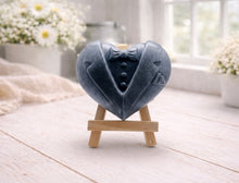 Load image into Gallery viewer, A pair of handmade vegan soaps shaped like hearts and displayed on miniature wooden easels; one heart is textured like a grey tuxedo with a bow tie and buttons, and the other is a white bridal gown heart with intricate lace patterns and a pearl necklace detail.