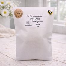 Load image into Gallery viewer, White bag with a label on a wooden surface with flowers in the background