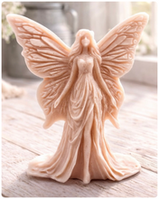 Load image into Gallery viewer, A detailed handmade vegan soap featuring an elegant fairy with large, intricate butterfly-style wings, a flowing gown, and long hair, standing against a bright farmhouse window background.
