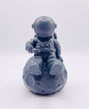Load image into Gallery viewer, Handmade vegan soaps featuring a detailed astronaut / spaceman sitting  on the moon. crafted with natural French clays, activated charcoal and essential oils. a eco-friendly, zero waste gift that’s cruelty-free, skin-nourishing, and perfect for space lover gifts. gifts for him. Wrapped in beautiful eco friendly packaging. Small Business UK
