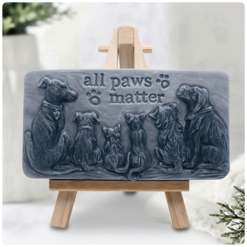 Handmade All Paws Matter vegan soap bar made with activated charcoal displayed on a wooden easel featuring an embossed pet design.