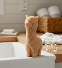Load image into Gallery viewer, highly detailed handmade vegan soap in the shape of a cute alpaca or llama with a textured woolly finish, displayed against a whimsical farmhouse decor background
