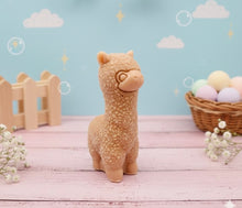 Load image into Gallery viewer, highly detailed handmade vegan soap in the shape of a cute alpaca or llama with a textured woolly finish, displayed against a whimsical farmhouse decor background
