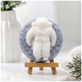 handmade vegan soap in the shape of a realistic astronaut sculpture sitting on the moon, featuring detailed spacesuit textures and craters on the lunar surface, displayed in a bright farmhouse decor setting.