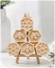 Load image into Gallery viewer, A handmade vegan soap gift set featuring six hexagonal bars stacked in a pyramid on a small wooden easel; some bars show a honeybee relief and others a honeycomb pattern
