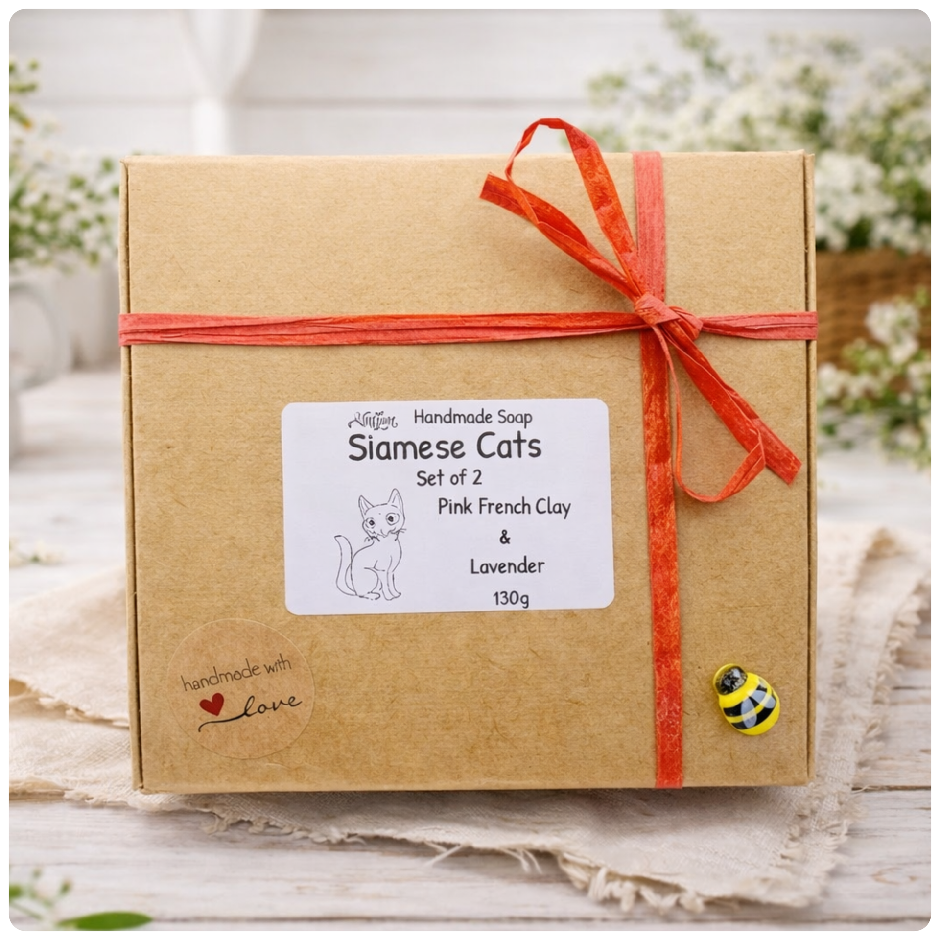 Handmade soap packaging with a label and orange ribbon on a neutral background