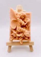 Load image into Gallery viewer, Handmade vegan soaps shaped as a beautiful elegant fairy holding a flower. crafted with natural French clays, activated charcoal and essential oils. a eco-friendly, zero waste gift that’s cruelty-free, skin-nourishing, and perfect for fairy lovers and gifting. wrapped in beautiful eco friendly packaging. 
