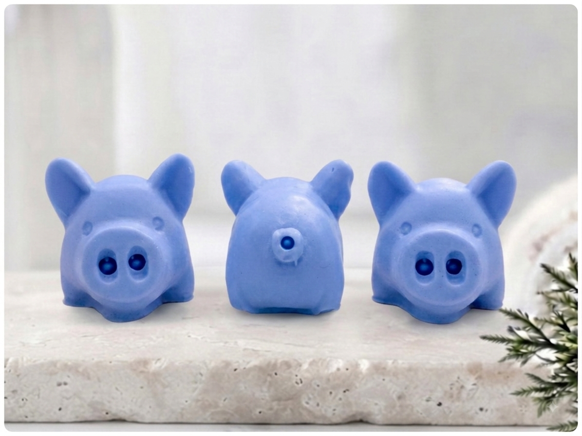 Handmade chunky pink pig soap gift set of three, each with detailed ears and shiny snouts, lined up on a stone surface. Unique decorative animal soaps by Soap Simple Creations, Blackpool UK.