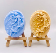 Load image into Gallery viewer, Handmade vegan Guardian Angel soap bar, features a detailed angel with flowing wings. Natural, cruelty-free UK soap ideal for spiritual gifts, zero waste skincare, and sustainable bathroom décor. British-made artisan soap perfect for eco-conscious shoppers. Wrapped in beautiful eco friendly packaging . Small business UK
