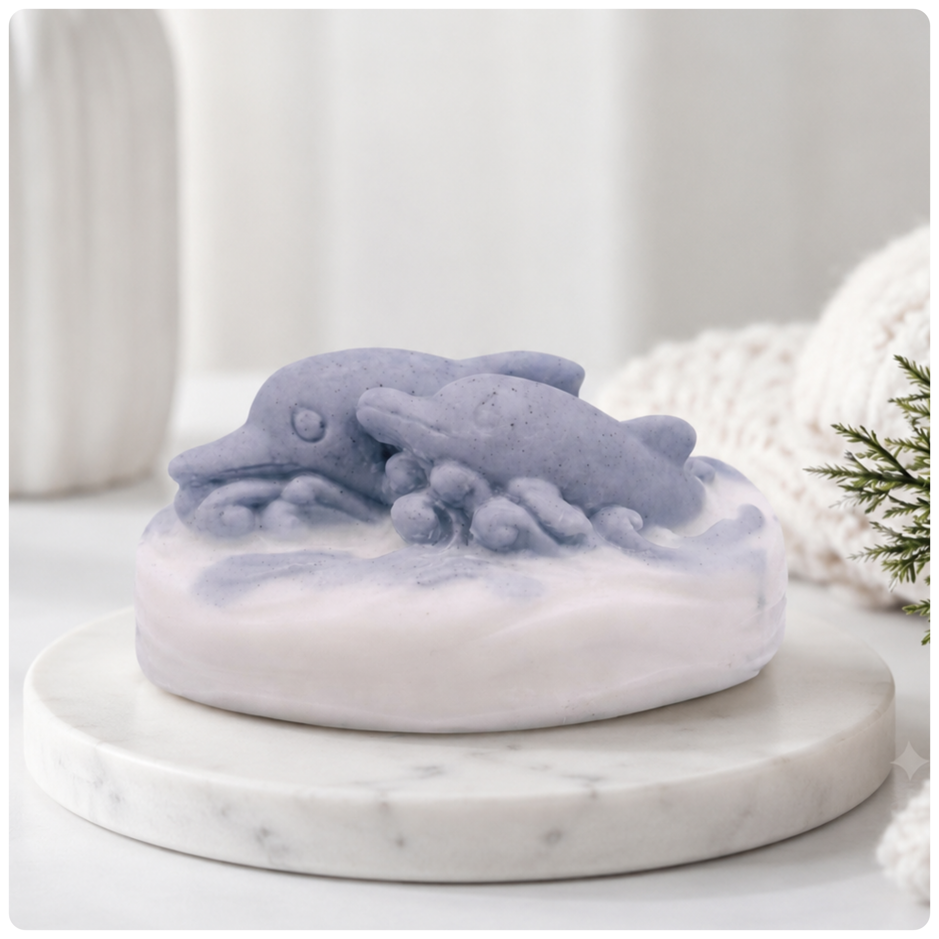 A handmade vegan soap featuring two grey dolphins jumping through white frothy waves; the base is white, and the dolphins are highly detailed, displayed on a light wooden surface against a soft farmhouse background.