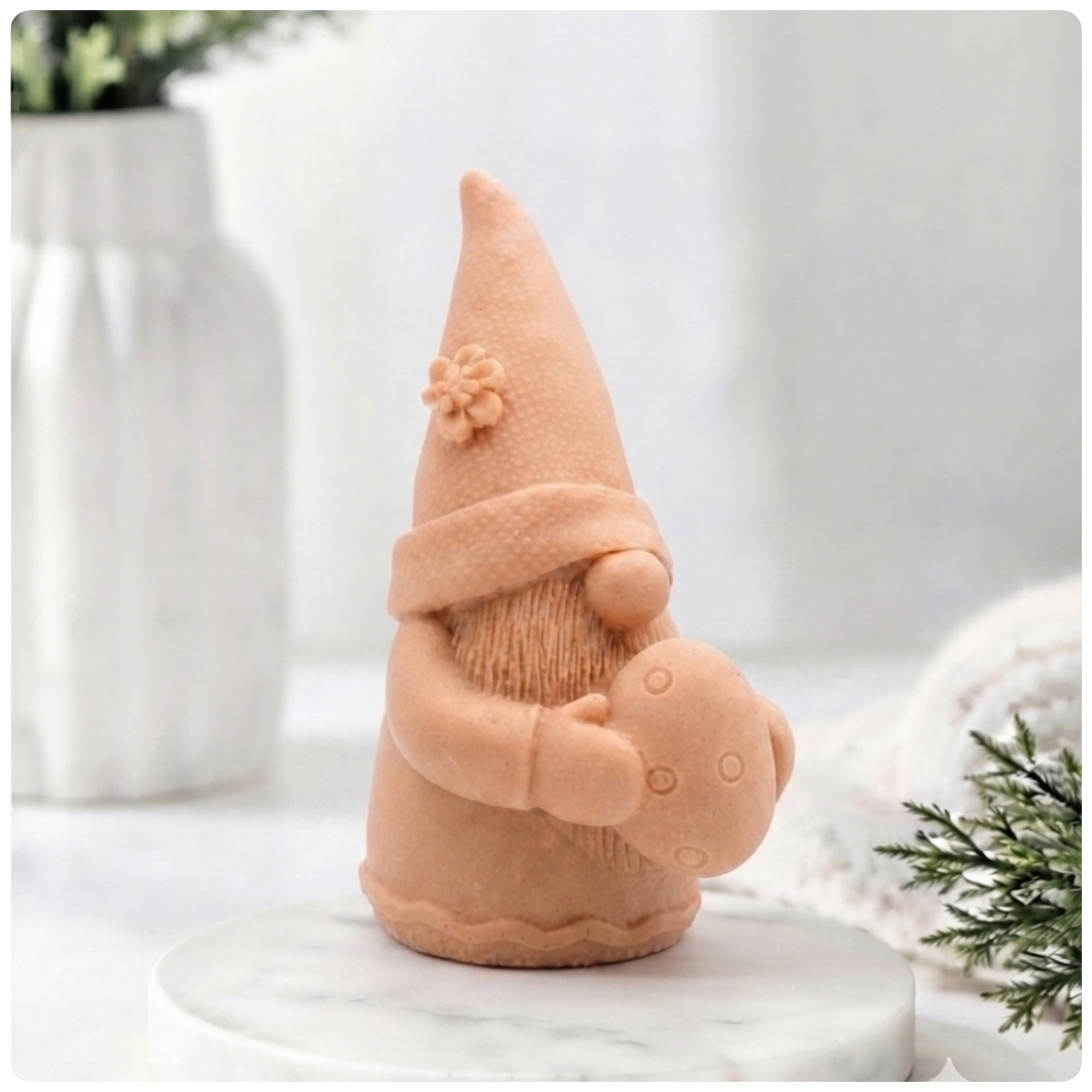 A detailed handmade vegan soap gift,  sculpted as a whimsical Easter gnome (gonk) wearing a tall pointed hat with a flower detail, holding a large patterned Easter egg.