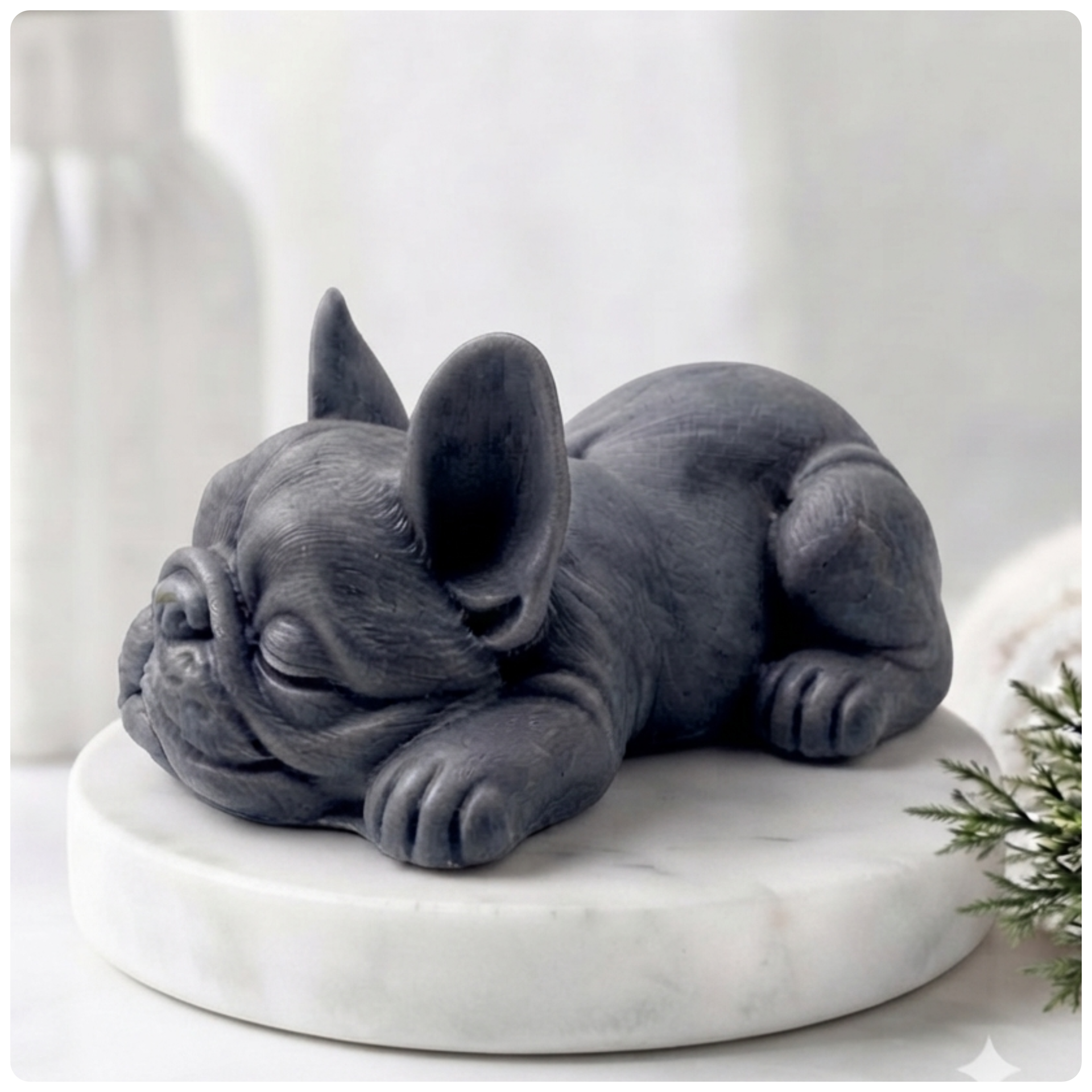 Handmade vegan soap in the shape of a realistic sleeping French Bulldog lying down, showing detailed ear texture and facial wrinkles, surrounded by bubbles in a marble bathroom setting.