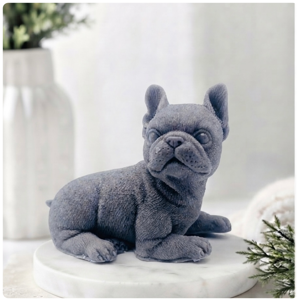 A highly detailed handmade vegan soap in a sophisticated yellow tone, sculpted in the shape of a French bulldog puppy sitting upright with its characteristic large ears and wrinkled face, displayed on a light wooden surface.