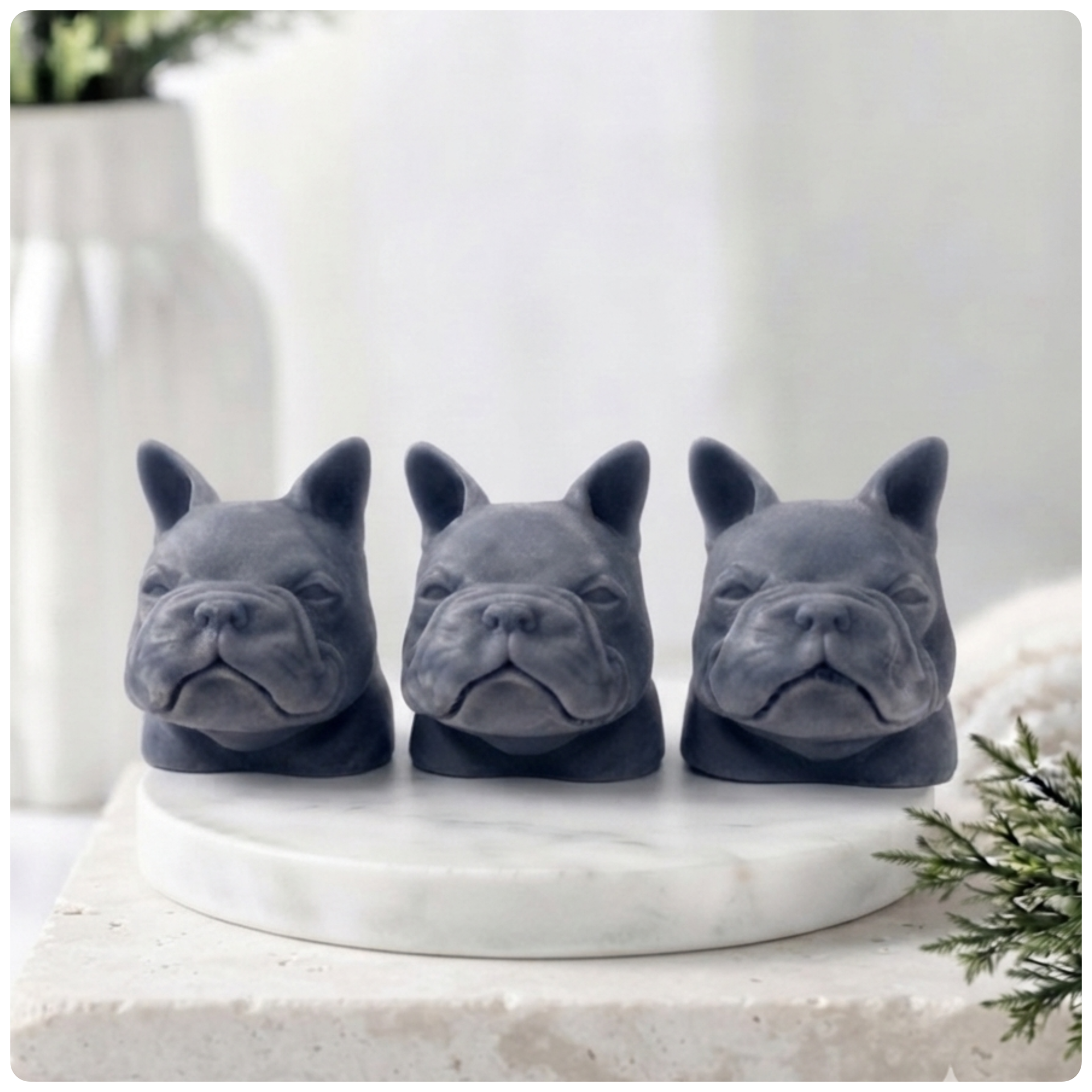 Three French bulldog-shaped soaps on a white surface with decorative elements.