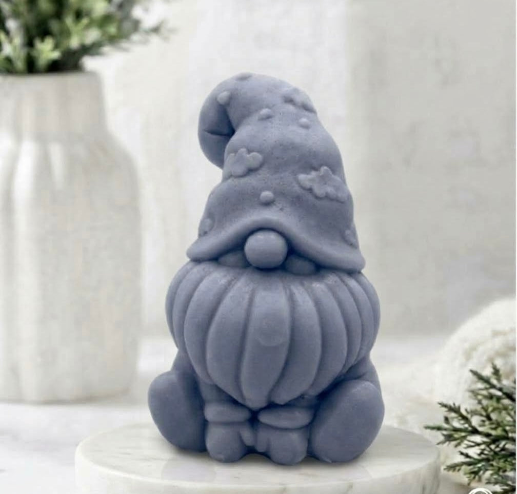 A handmade vegan soap in charcoal grey, sculpted as a gnome (gonk) with a tall, curved hat that covers the eyes and has clouds on it, a round nose, and a long, textured beard.