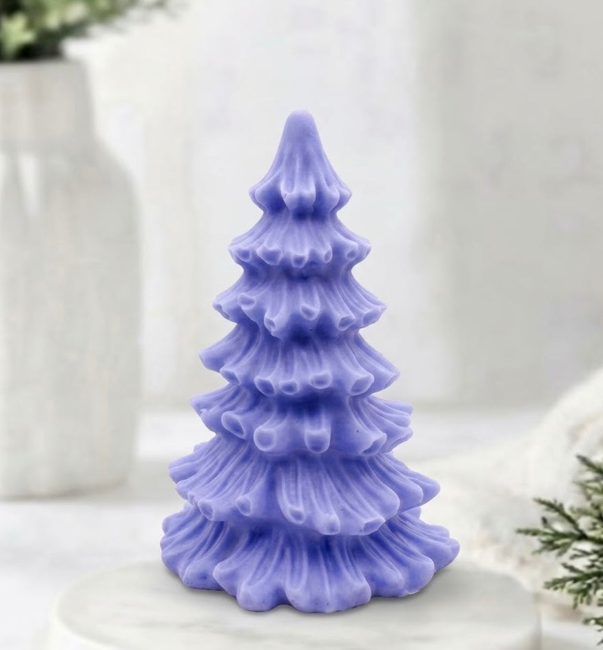 A blue vegan soap sculpted into a realistic evergreen Christmas tree with multiple layers of textured, needle-like branches, with a subtle snow-dusted effect.