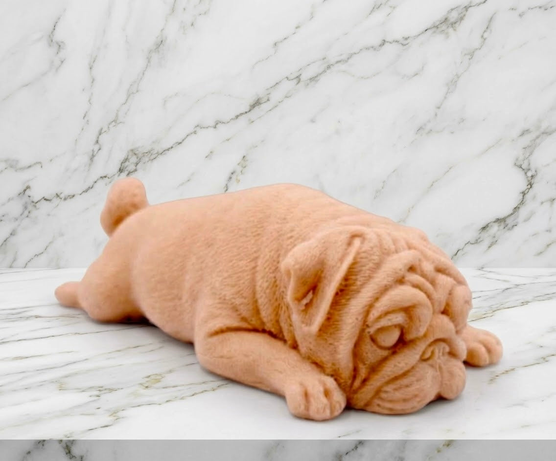 A terracotta sleeping pug-shaped vegan soap gift. resting on a light marble surface with a soft background.