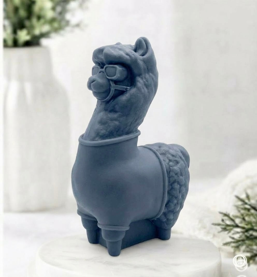 A charcoal grey coloured decorative llama / alpaca shaped vegan soap on a white surface.
