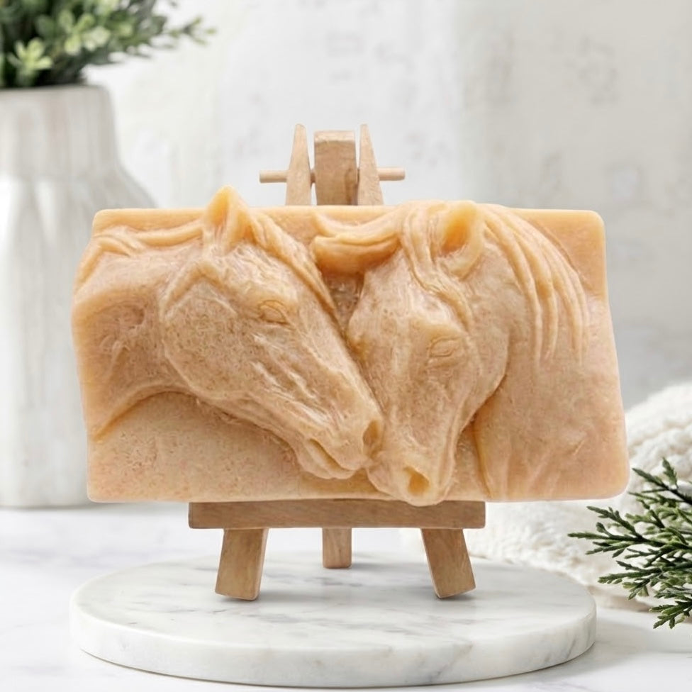 A soft yellow vegan soap bar featuring a detailed, intricate high-relief carving of a mare and foal horses nuzzling. Handmade cruelty-free artisan product, sculpted animal soap.