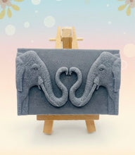 Load image into Gallery viewer, Handmade vegan soaps featuring two elephants who&#39;s trunks meet in a heart shape packed in beautiful eco friendly packaging. crafted with natural French clays, activated charcoal and essential oils. a eco-friendly, zero waste gift that’s cruelty-free, skin-nourishing, and perfect for elephant lovers or animal themed gifts. Small business UK
