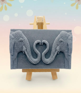 Handmade vegan soaps featuring two elephants who's trunks meet in a heart shape packed in beautiful eco friendly packaging. crafted with natural French clays, activated charcoal and essential oils. a eco-friendly, zero waste gift that’s cruelty-free, skin-nourishing, and perfect for elephant lovers or animal themed gifts. Small business UK