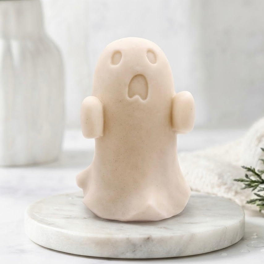A front view of a soft yellow ghost soap gift on a marble base.
