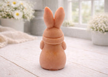 Load image into Gallery viewer, A detailed handmade vegan soap in a natural colour, sculpted as a whimsical Easter gnome (gonk) with long rabbit ears and a bow on its hat, holding a patterned Easter egg, displayed on a light wooden surface. Easter gift 
