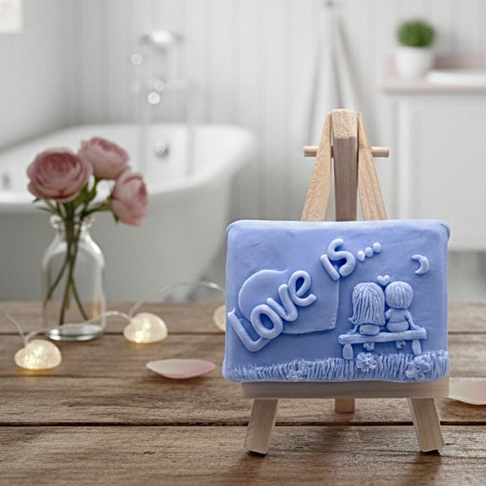 Handmade vegan soaps featuring a boy and girl sat on a bench with the wording Love Is... ,  in beautiful eco friendly packaging. 