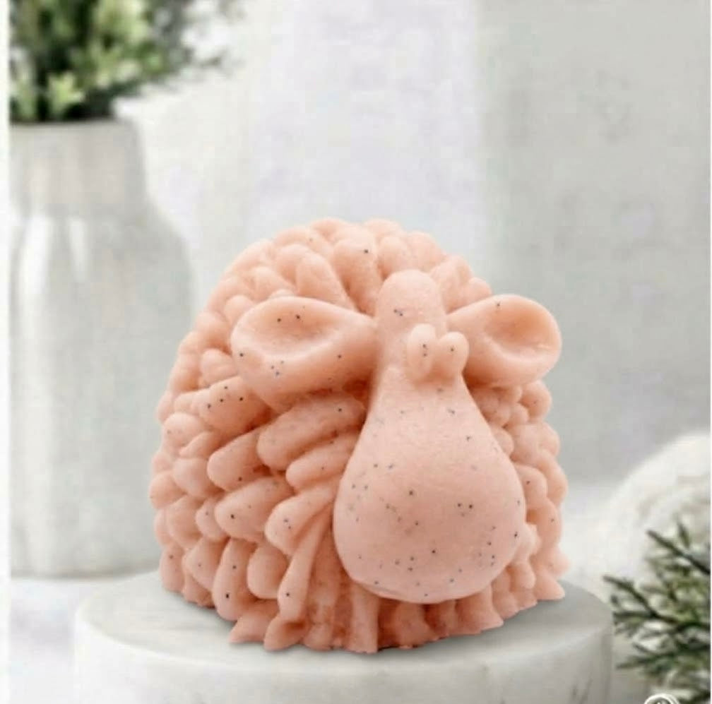 A highly detailed soft pink handmade vegan soap sculpted in the shape of a fluffy sheep with thick, textured wool and a smooth face