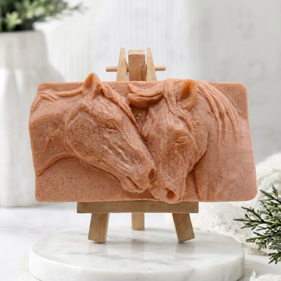 A deep terracotta-coloured vegan soap bar with an intricate, high-relief carved design of a mare and foal nuzzling horses. This handmade, cruelty-free soap is a highly detailed artisan product for horse lovers.