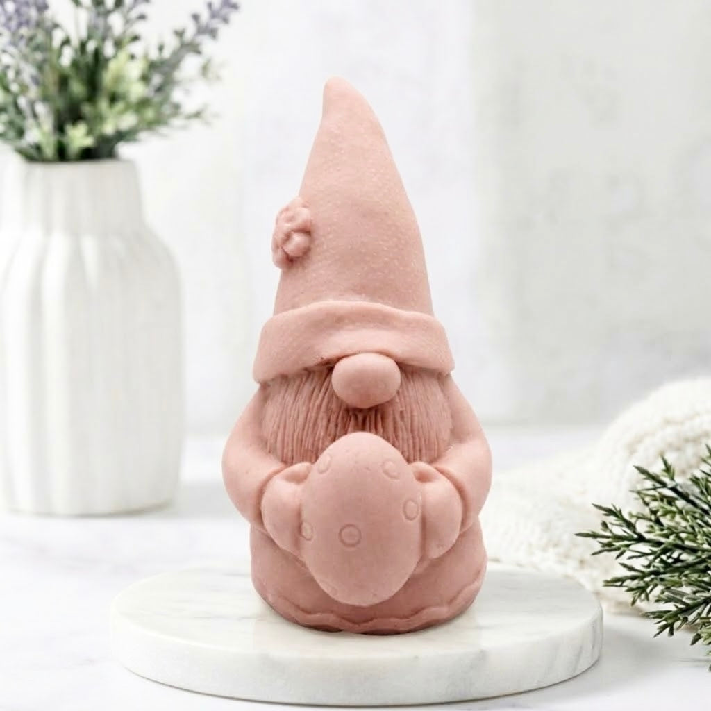 A soft pink gnome soap with a tall pointed flower hat, holding an Easter egg. 
