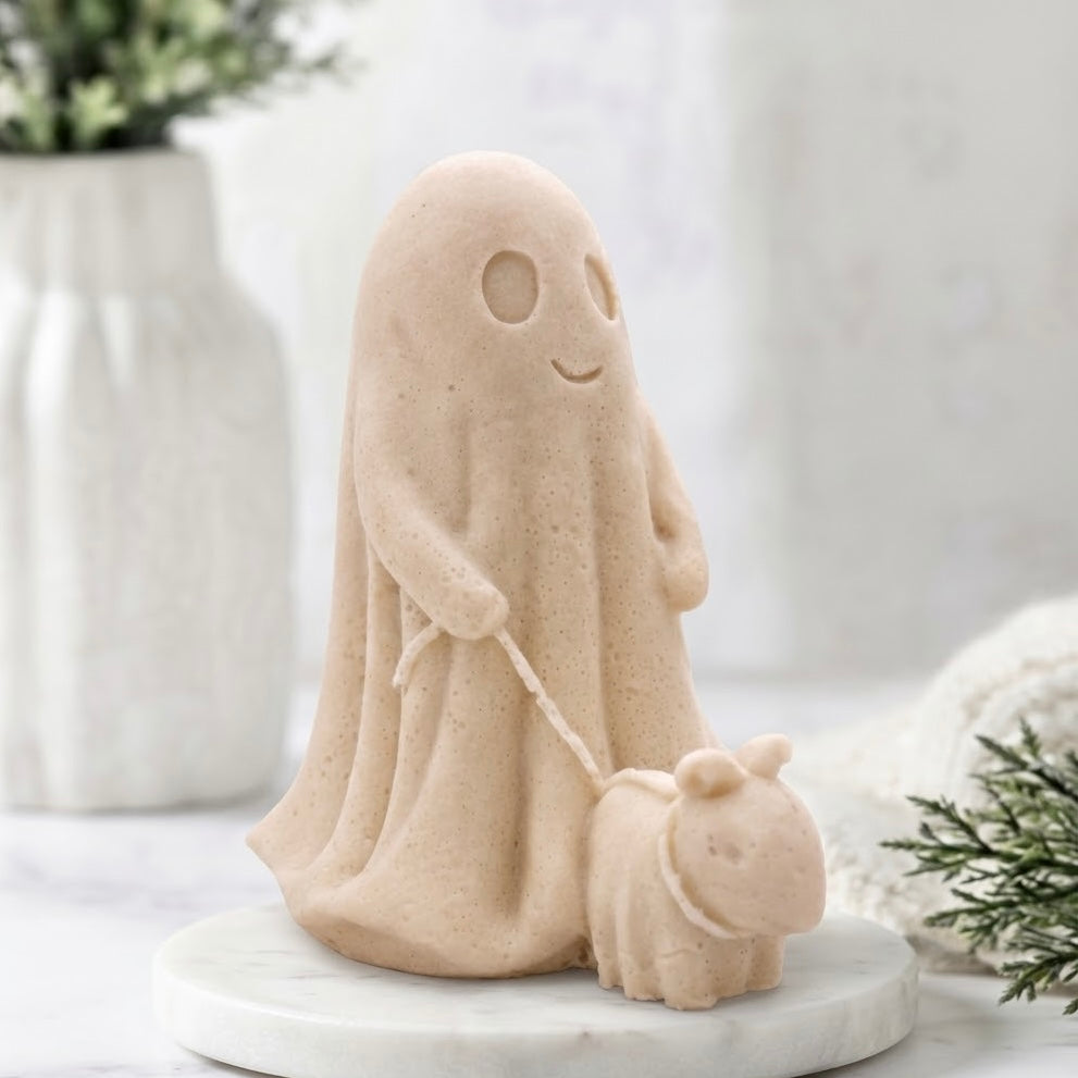 A soft yellow decorative vegan soap figure of a ghost with a dog on a leash in a bright room with flowers.