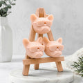 Artisan Frenchie novelty soap gift set, featuring three pale pink dog-shaped soaps in sunglasses stacked on a wooden easel display stand. Handcrafted gift for French Bulldog lovers.