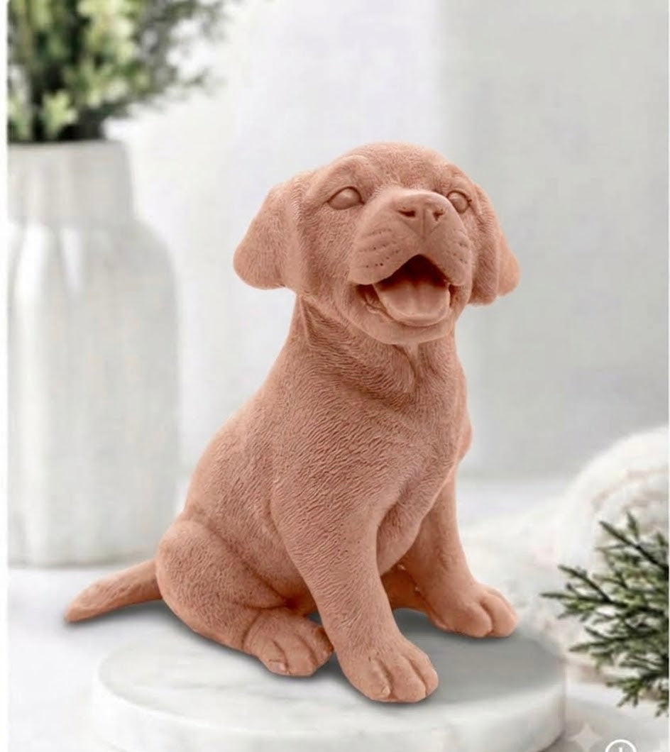 Front-facing view of a warm terracotta-toned red French. Clay handmade Labrador puppy dog vegan soap bar sitting attentively with an open mouth.