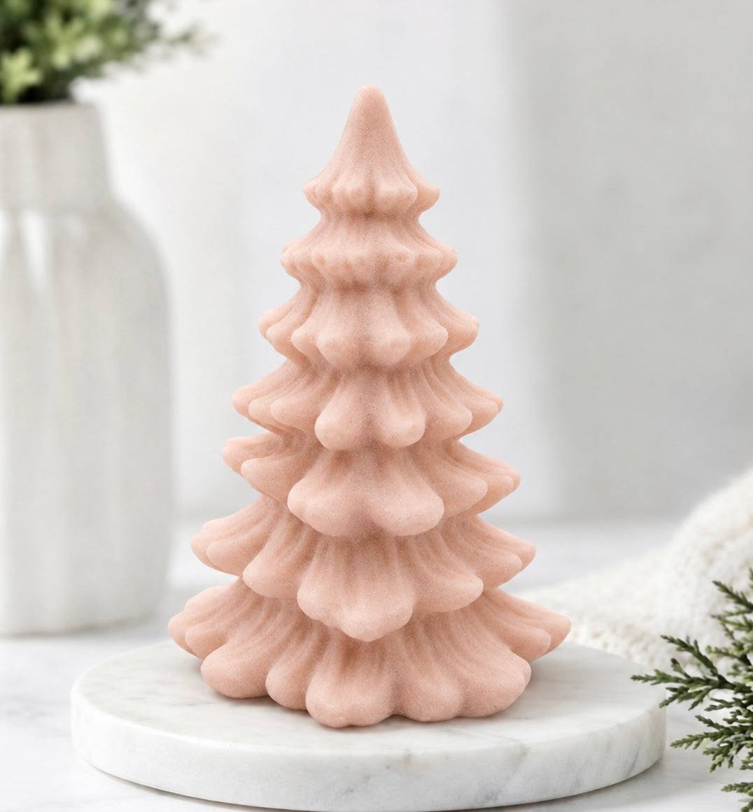 Soft pink vegan soap sculpted into a realistic evergreen Christmas tree with multiple layers of textured, needle-like branches, with a subtle snow-dusted effect.